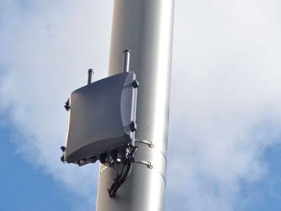 Close-up of a small cell antenna attached to a metal pole