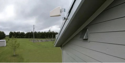 Small cell antenna mounted on the side of a residential house